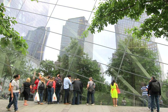 Tourists look peer through the windows of the 9/11 Museum